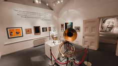 an old horn is on display in a museum with pictures and other items around it