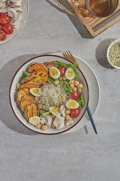 a plate with chicken, tomatoes, lettuce and hard boiled eggs