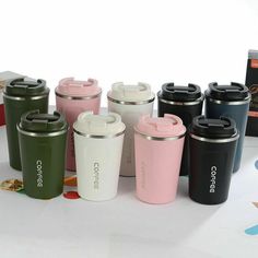 the coffee cups are lined up next to each other in different colors and sizes,