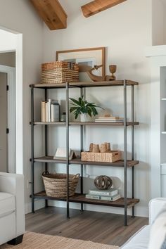 A modern farmhouse living room featuring a minimalist metal and wood shelving unit elegantly decorated with natural textures and green plants.