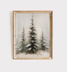 a painting hanging on the wall next to a white wall with snow covered trees in it