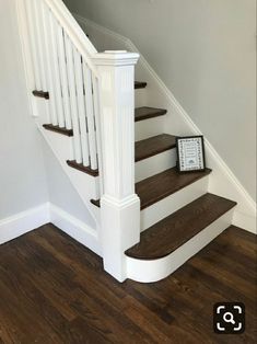 there is a clock sitting on the stairs next to the bannister in this house