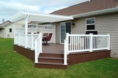 a white pergolan sitting on top of a wooden deck