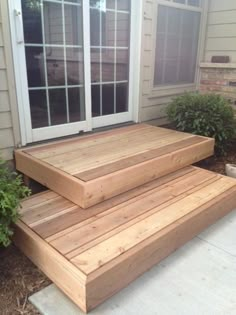 two wooden steps sitting next to each other in front of a house