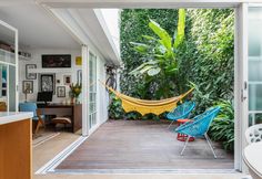 a hammock hanging in the middle of a room next to a table and chairs