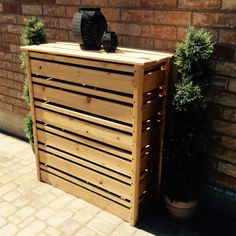 a wooden bench next to a brick wall and potted planter on the sidewalk