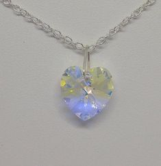 This beautiful Swarovski Crystal Clear AB heart-shaped pendant hangs on a sterling silver chain.**AB (Aurora Borealis) is a shimmering, iridescent rainbow effect that creates an even greater sparkling quality to the base color and reflects varying colors depending on the angle of light. Pick you chain:16" Cable, 18” Cable, 20” Cable, or 24" CablePendant Size: 14x14mm Necklace is packaged in a white cotton-filled gift box.**Matching Earrings Available**https://www.etsy.com/SunshineJazzyJewels/lis White Heart-shaped Crystal Necklace Gift, Iridescent Pendant Crystal Necklace For Gift, Iridescent Nickel-free Pendant Jewelry, Aurora Borealis Crystal Jewelry, Multicolor Nickel-free Crystal Necklace As Gift, Starfish Necklace, April Birthstone, Personalized Pendant, Birthstone Gifts