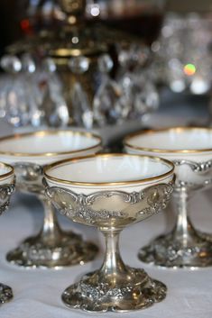 four silver goblets sitting on top of a table