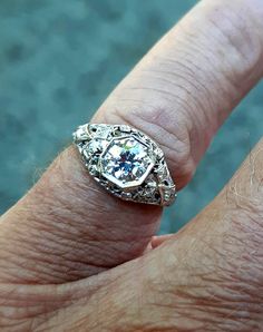 A wonderful Victorian band with great filigree detail. The center stone measures out at .80 ct and has a clarity of SI1 and G color. There is a small natural crystal on the girdle. On either side are 2 @.05ct diamonds set in diamond shape gold. The band weighs 2.5 grams and is is excellent condition. It measures 8.5mm across the top. Antique Brilliant Cut Diamond White Ring, Antique Brilliant Cut Diamond White Diamond Ring, Antique Diamond White Diamond Ring With Brilliant Cut, Brilliant Cut Diamond White Diamond Ring For Marriage, Dazzling Brilliant Cut Diamond Marriage Ring, Dazzling Brilliant Cut Diamond Ring For Marriage, Antique Diamond White Diamond Ring, Antique White Gold Diamond Jewelry, Heirloom Diamond Ring With Brilliant Cut