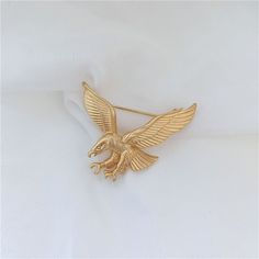 Add a touch of class to any outfit with this exquisite Gold Eagle Brooch. Show off your bold style and make a statement with this eye-catching accessory, perfect for both men and women. Surprise someone special with the perfect gift!👌 M A T E R I A L• 18K Gold plated over brass• This product is hypoallergenic (nickel free) and tarnish resistant📏 S I Z E• Length: 3.8 cm (1.5 inch)• Width: 3.2 cm (1.3 inch)• Weight: 6.5 g Luxury Gold Enamel Pin For Formal Occasions, Gold Formal Enamel Pin, Luxury Gold Brooch Lapel Pin, Luxury Gold Enamel Pin As Gift, Luxury Gold Enamel Pin For Gift, Luxury Gold Enamel Pin Gift, Luxury Gold Lapel Pin For Anniversary, Luxury Gold Pins For Anniversary, Gold Brooch Pin As Gift