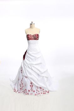 a white dress with red flowers on it and a mannequin in the background