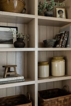 the shelves are filled with books and baskets