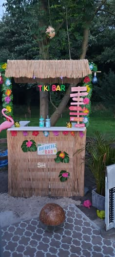 a tiki bar decorated with flowers and flamingos for a birthday or baby shower