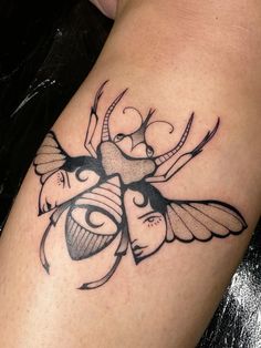 a black and white tattoo on the leg of a woman's thigh with a bee