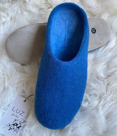 Super warm and soft, our 100% natural felt wool slippers are so warm and comfy, you will not want to take them off! Handmade boiled wool slip-ons made by skilled artisans in a small fair trade workshop in Nepal. - Material: 100% New Zealand Wool - Soles: 100% Suede - Colour: Deep Ocean Blue - Size: 8, 9, 10, 11, 12 UK (42, 43, 44, 45, 46 EU)- will also fit 1/2+ UK as the slippers are flexible and will give slightly to mould to your feet - Style: Mule slip-on About us- LUZ Fair Trade  is a small Anglo-Peruvian brand bringing you timeless alpaca and sheep's wool accessories, slippers and home wear from Peru and Nepal. Our goal is to bring you the finest alpaca and sheep's wool products with our key values of fair trade, quality, and tradition. Winter Felt Slip-on Clogs, Comfortable Soft Blue Slippers, Comfortable Blue Winter Slippers, Winter Felt Slippers With Soft Sole, Comfortable Blue Slippers With Rubber Sole, Blue Indoor Slippers With Rubber Sole, Winter Felt Slippers With Round Toe, Felt Slip-on Slippers With Soft Sole, Winter Felt Slippers With Closed Toe