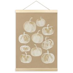 a brown wall hanging with white pumpkins on it