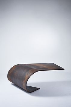 a wooden table that is shaped like a curved piece of wood, on a white background