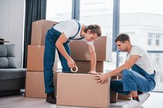 two men unpacking boxes in the living room with their hands on each other