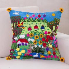 a colorful pillow sitting on top of a white chair