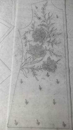 a drawing of a dress with flowers and leaves on the front, sitting on top of a piece of paper