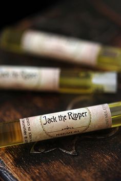 jack the ripper roll - ons sitting on top of a wooden table next to an empty bottle