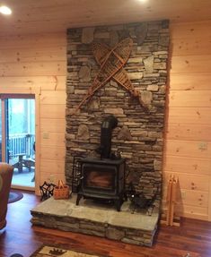 a living room with a stone fireplace and wood burning stove