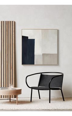 a chair and table in a room with a painting on the wall