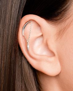 a woman's ear is shown with an arrow on the side and a chain attached to it