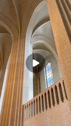 the inside of a building with columns and arches on it's sides, looking up at the ceiling