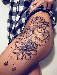 a woman is showing off her thigh with flowers on the side and in the middle