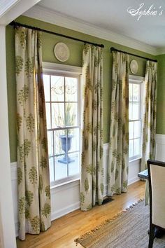 a living room with green walls and curtains