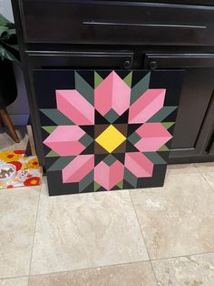 a black cabinet with pink, yellow and green flowers painted on it