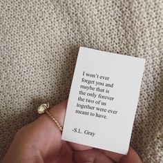 a person holding a card with a quote on it in their left hand and a gold ring