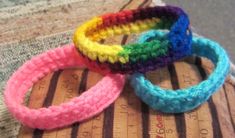 three crocheted bracelets sitting on top of a piece of fabric