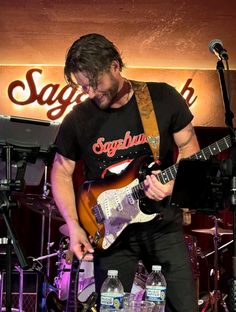 a man playing an electric guitar on stage