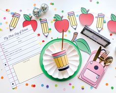 an assortment of stationery items on a table with confetti and pencils