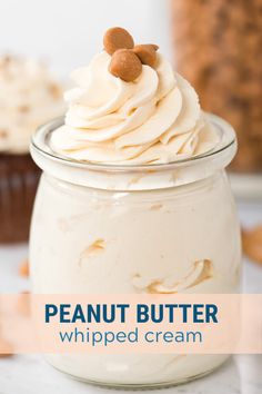 a glass jar filled with whipped cream and topped with walnuts next to a cupcake