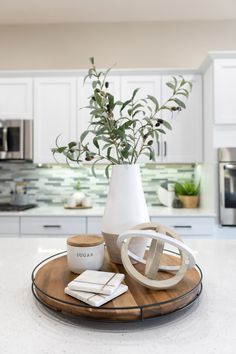 a white vase sitting on top of a wooden tray