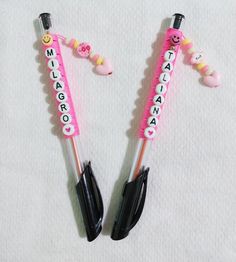 two pink and black umbrellas with smiley faces on them, sitting next to each other