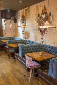 an empty restaurant with blue booths and wooden tables