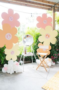 an outdoor party with flowers and balloons on the ground, in front of a mirror