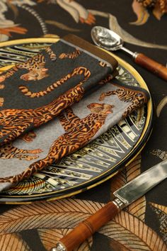 a table topped with a plate covered in tiger napkins