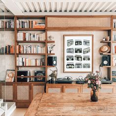 a wooden table sitting in front of a bookshelf filled with lots of books