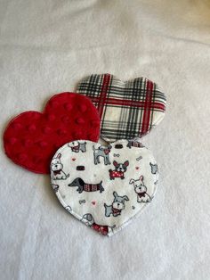 three pieces of fabric with different designs on them sitting on a white cloth covered surface