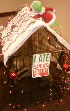 there is a dog in a cage with a sign that says ate santa's cookies