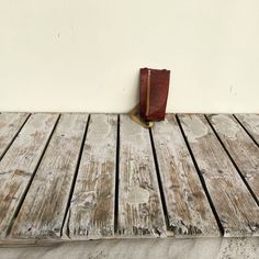 an open book sitting on top of a wooden table next to a white wall and floor