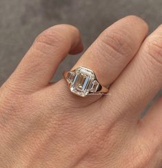 a woman's hand with an engagement ring on it, and the diamond in the middle