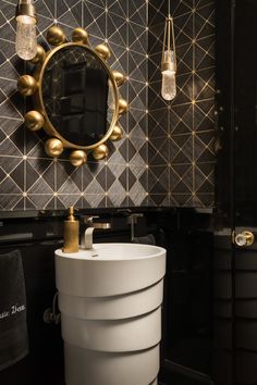 a black and white bathroom with gold accents