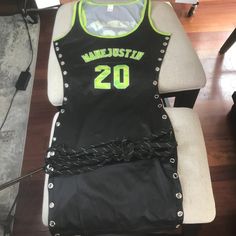 a black and green basketball jersey sitting on top of a chair with chains around it