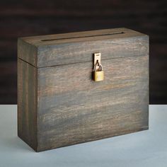 a small wooden box with a lock on it's front and side, sitting on a white surface